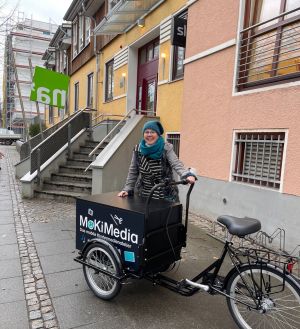 Tatjana Blaar mit MoKiMedia-Fahrrad vor dem na'
